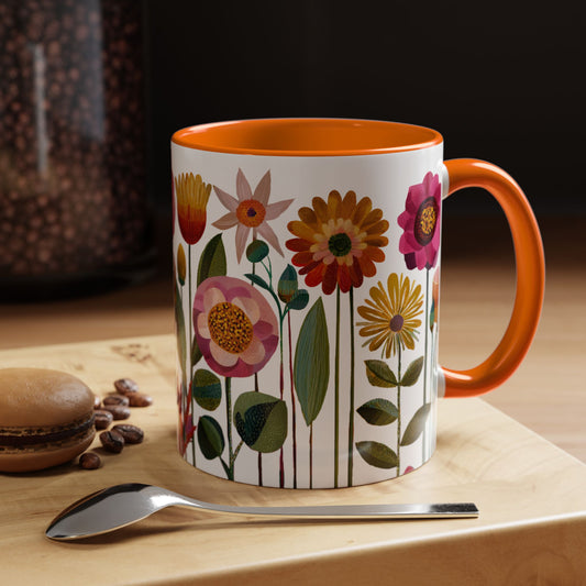 Orange Mug with floral design on a wooden surface with coffee beans and a spoon. Interior and handle are orange.