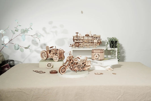 Wooden model trains and cars on a table with a decorative background Robotime Rokr Cruiser Motorcycle DIY Wooden Model 420 Pcs Building Wooden Kit
