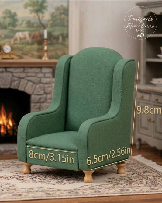 A miniature green upholstered armchair shown in a styled room scene with fireplace and rug, overlaid with dimension labels reading 9.8cm, 8cm/3.