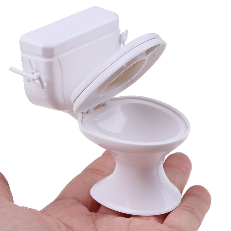 White dollhouse toilet in hand