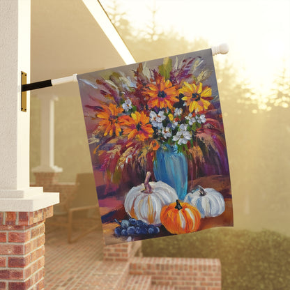 Decorative flag with a colorful floral arrangement and pumpkins hanging on a porch.
