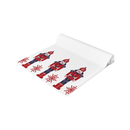 Folded white runner with red and blue nutcracker design on a white background
