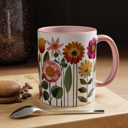 Pink Mug with floral design on a wooden surface with coffee beans and a spoon.