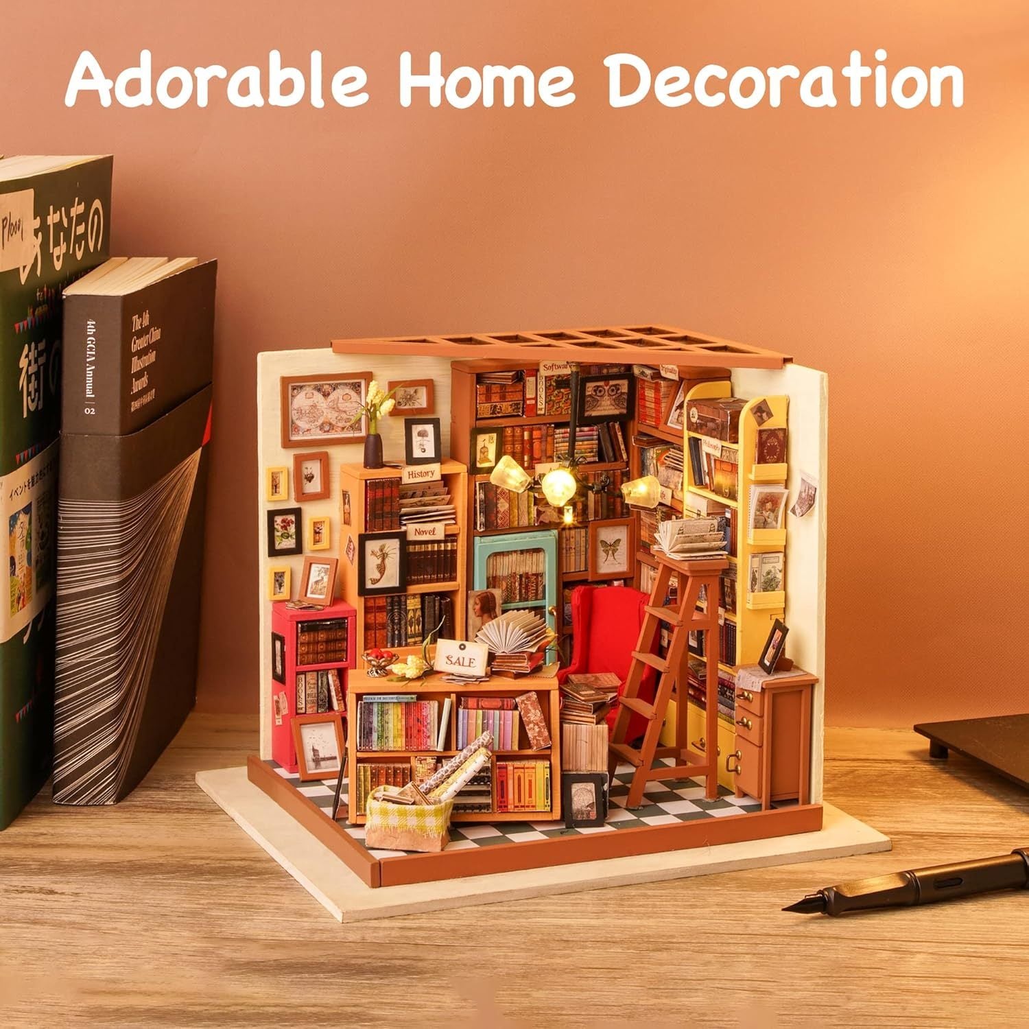 Miniature bookshelf model with books and decor on a wooden surface, labeled 'Adorable Home Decoration'. 1.24 scale miniature size