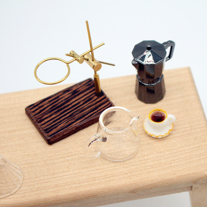 Miniature 1/12 Scale Dollhouse  coffee set with a glass mug, wooden coaster, and Moka pot on a wooden surface.