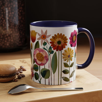 Navy colored Mug with floral design on a wooden surface with coffee beans and a spoon.
