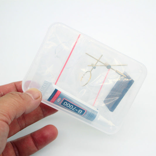 Hand holding a clear plastic container with sewing needles on a white background