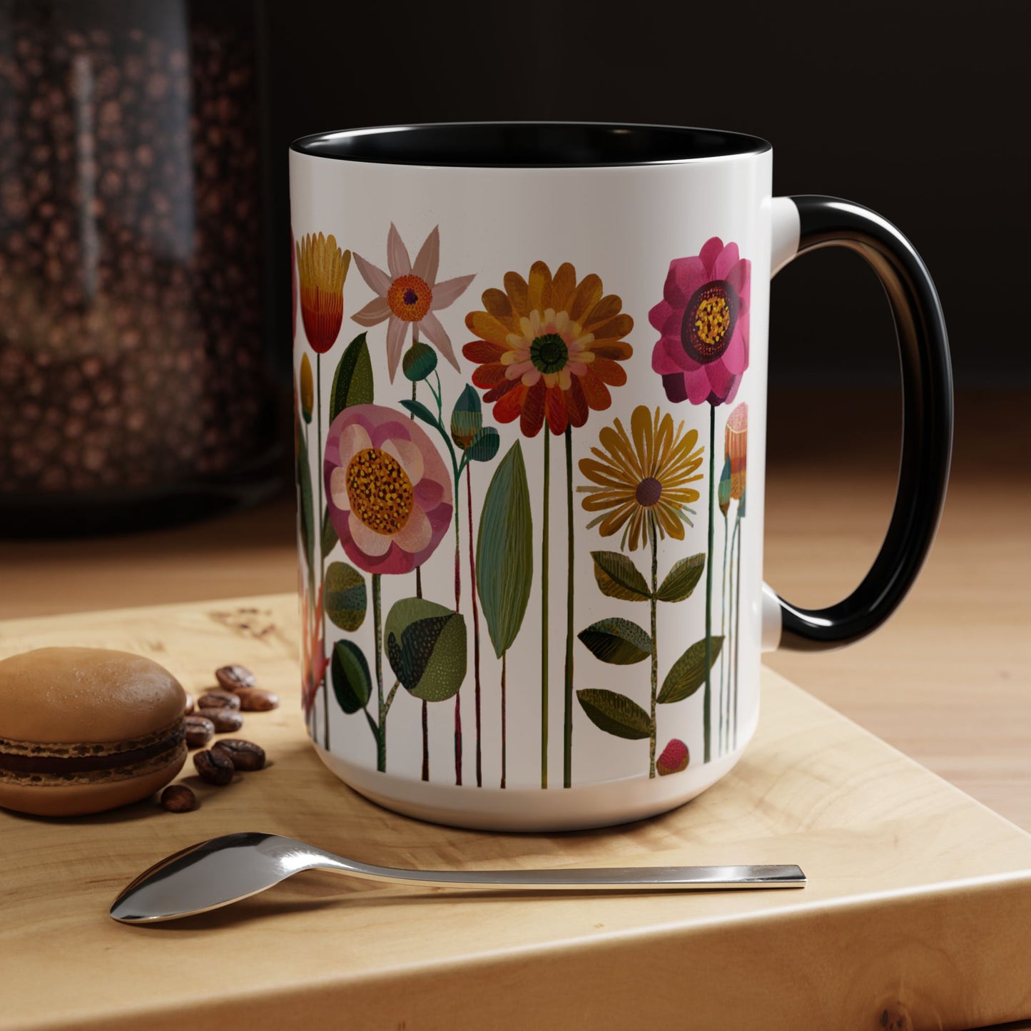 Black and White  15 oz mug with floral design on a wooden surface with coffee beans and a spoon.