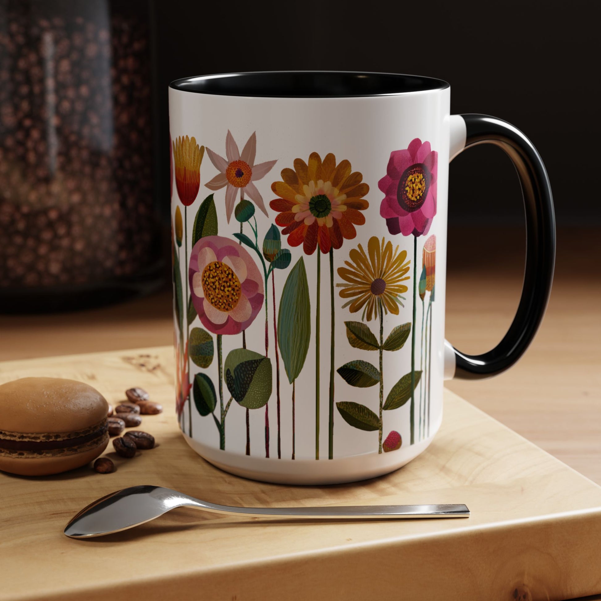 Black and White  15 oz mug with floral design on a wooden surface with coffee beans and a spoon.