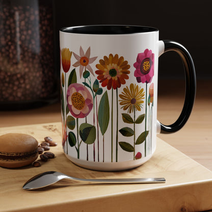 Black and White  15 oz mug with floral design on a wooden surface with coffee beans and a spoon.