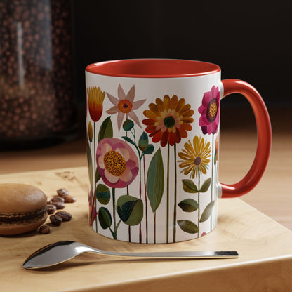 Red Mug with floral design on a wooden surface with coffee beans and a spoon.