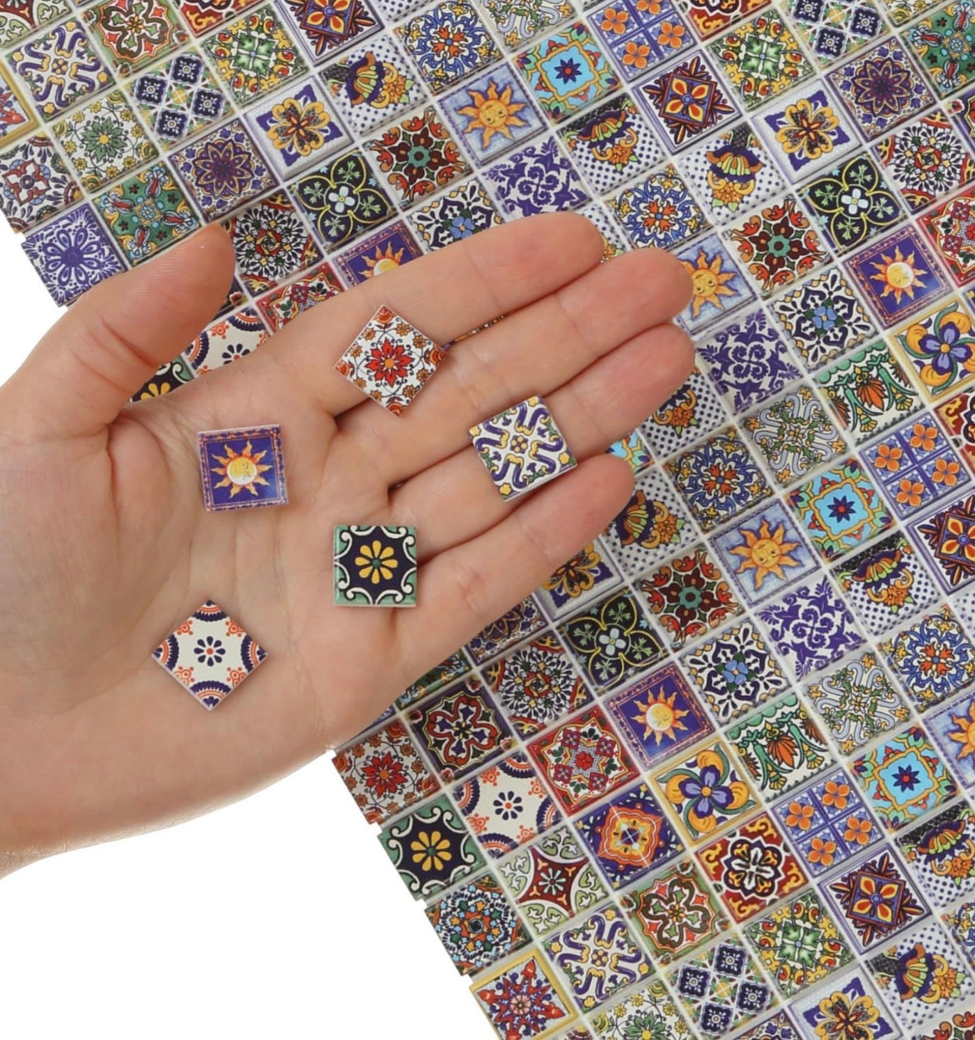 Hand holding decorative tiles with a colorful patterned background
