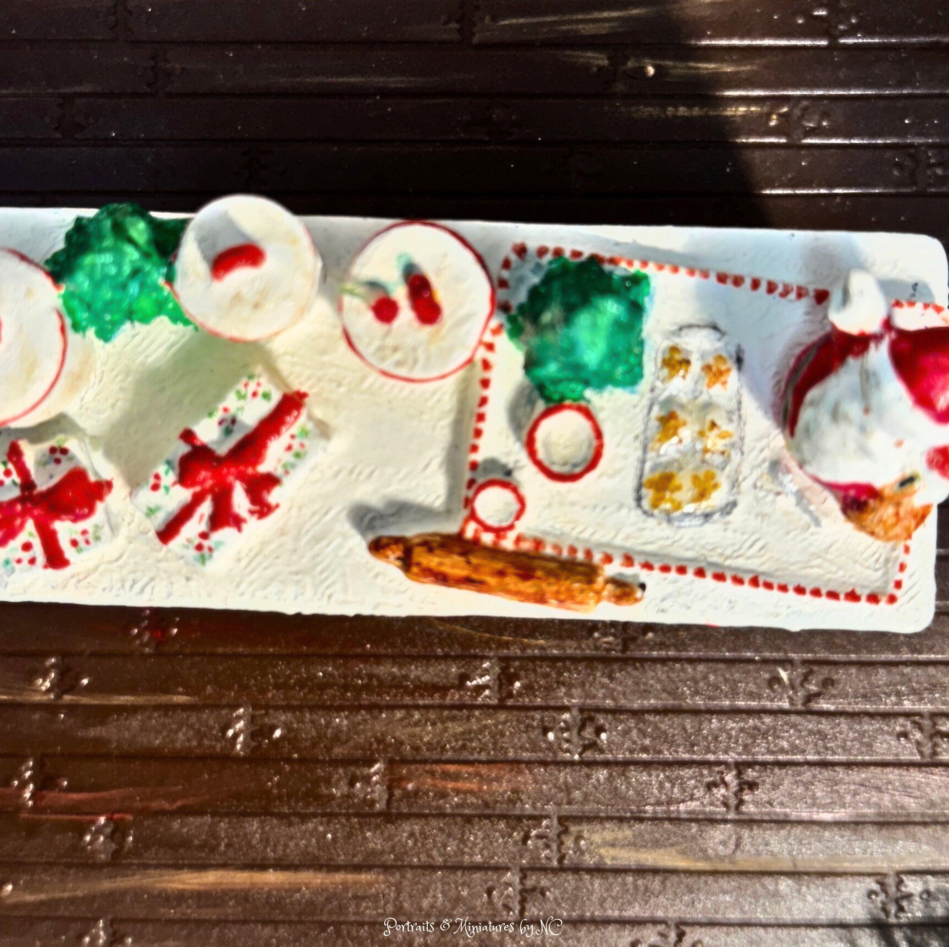Decorative Christmas-themed candy tray with Santa Claus and presents on a wooden surface.