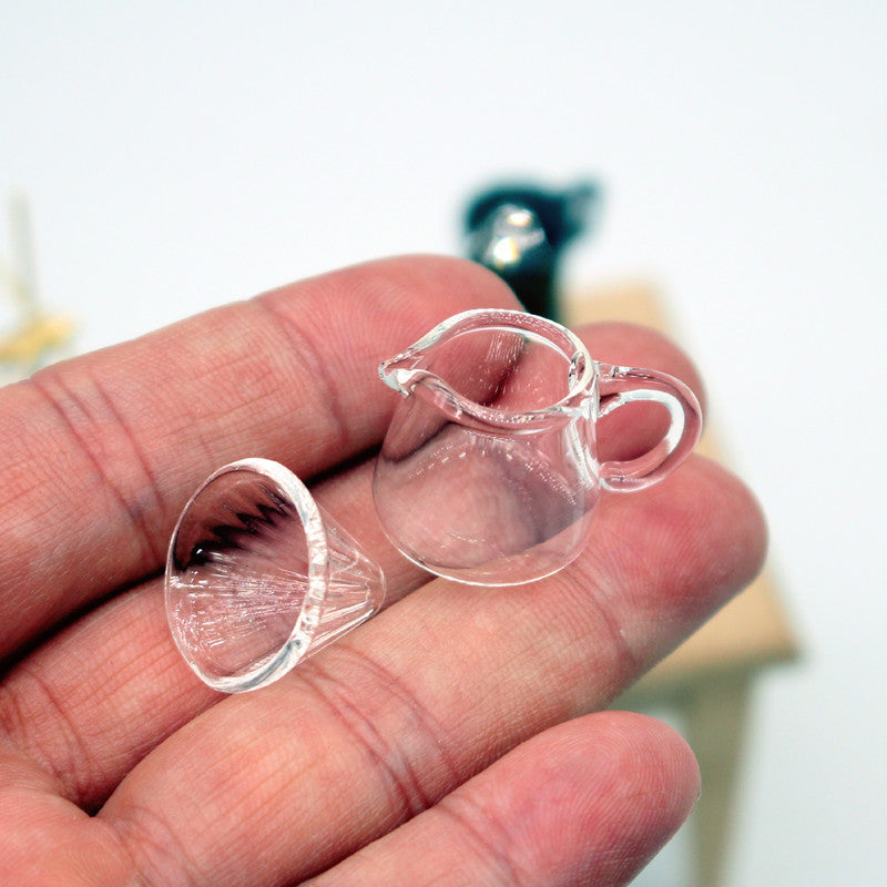 Clear plastic earbud holders on a person's hand with a blurred background 1/12 Scale Dollhouse 