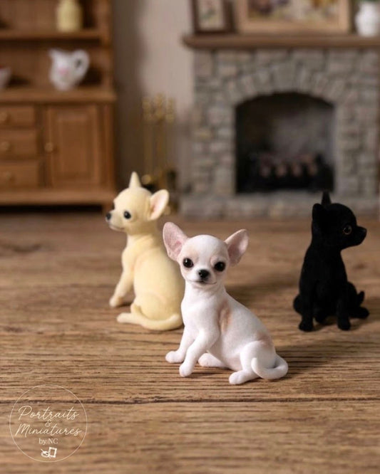 Three miniature Chihuahua figurines in cream, white, and black, displayed on a wooden surface with a blurred fireplace background. A 'Portraits Miniatures' logo is visible in the bottom-left corner.